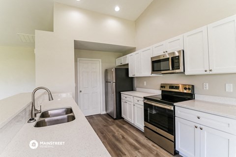 a kitchen with white cabinets and stainless steel appliances