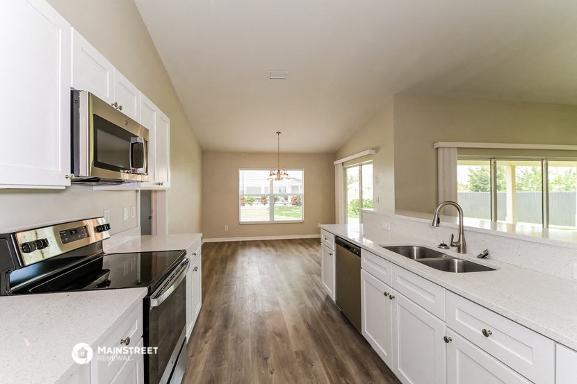 a large kitchen with white cabinets and black appliances