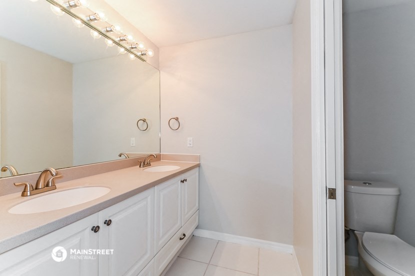 a bathroom with two sinks and a mirror and a toilet