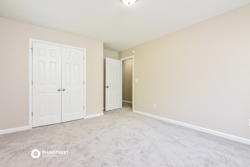 a bedroom with two doors and a carpeted floor