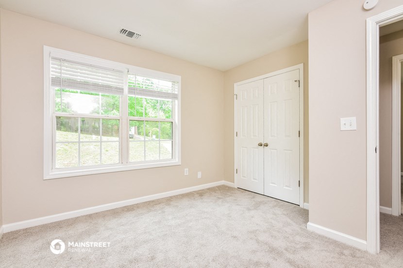 a bedroom with a large window and a white door