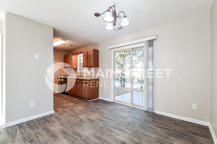a living room with a door to a kitchen