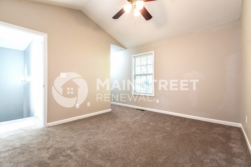 an empty living room with carpet and a ceiling fan