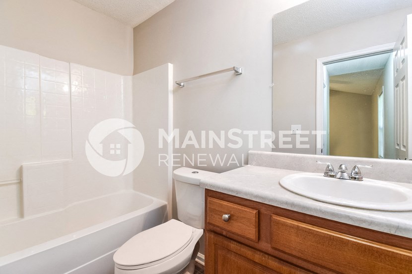 a small bathroom with a toilet and a sink and a tub