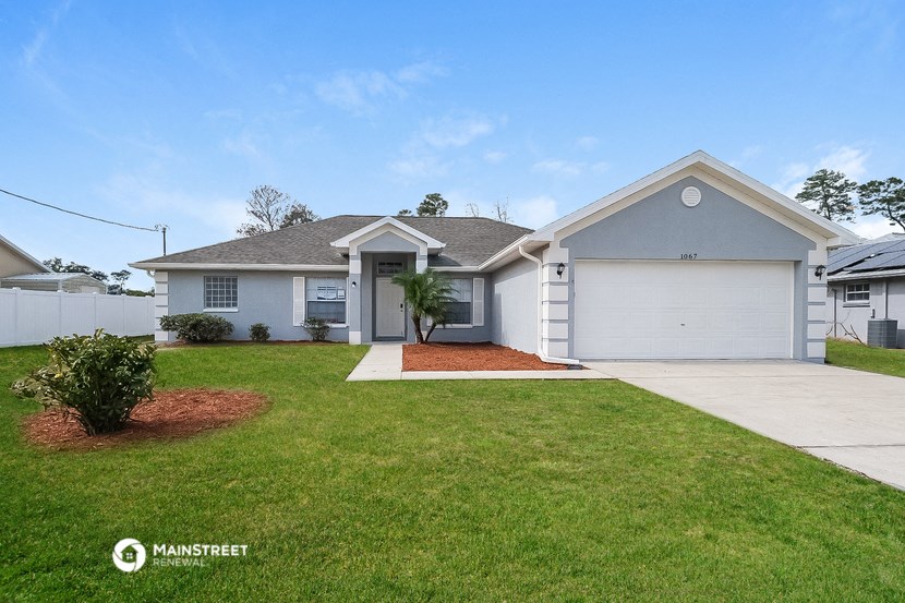 a white house with a lawn and a garage door