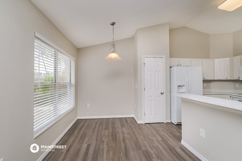 the living room and kitchen of an apartment with a large window