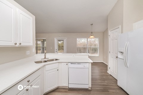 a kitchen with white cabinets and a sink and a refrigerator