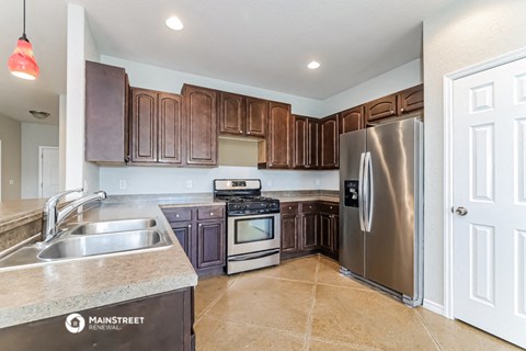 a kitchen with wooden cabinets and stainless steel appliances
