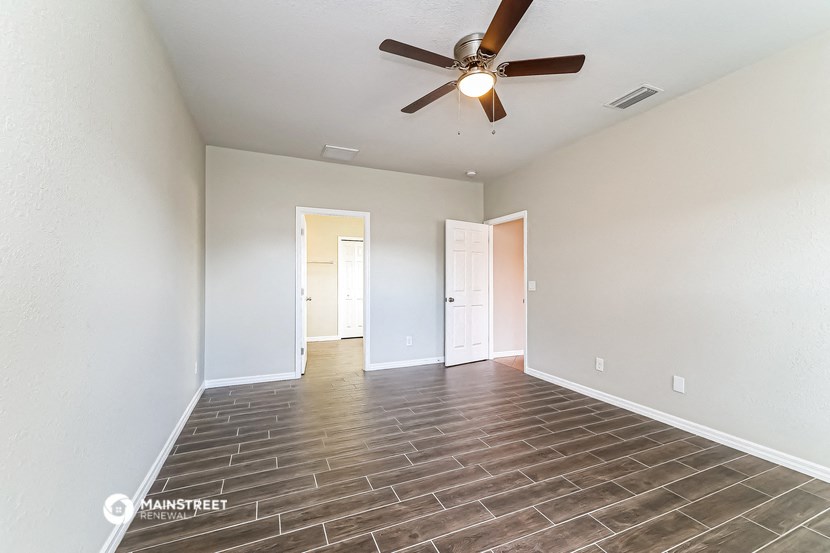 the living room of a new home with a ceiling fan