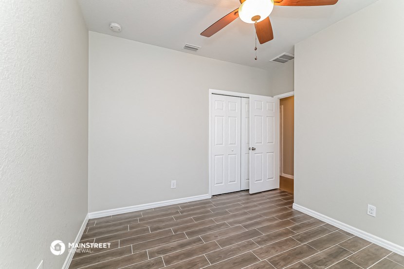 the living room has a ceiling fan and tile flooring
