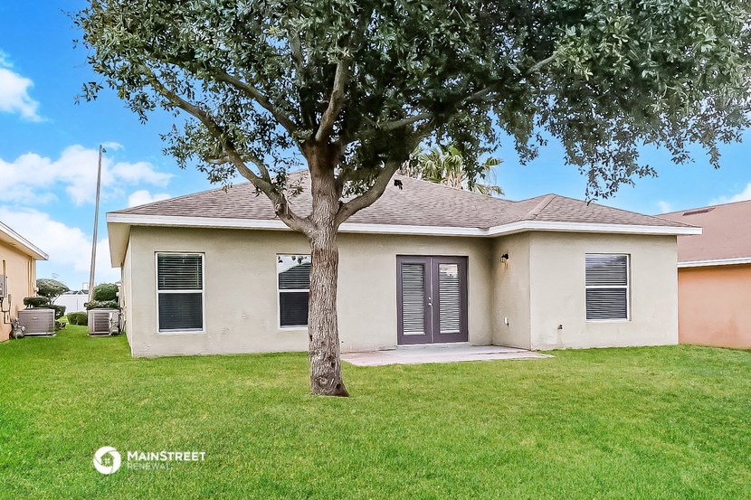 a white house with a tree in the yard