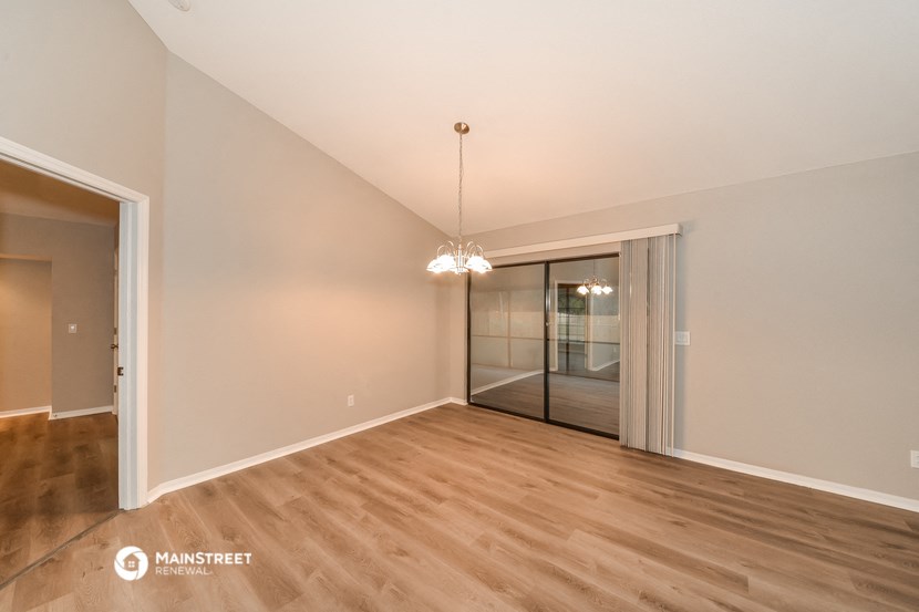 a living room with a sliding glass door and hardwood floors