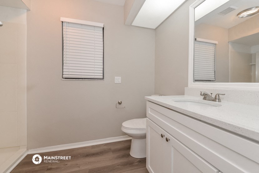 a bathroom with a toilet and a sink and a mirror