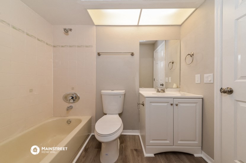 a white bathroom with a tub and a toilet and a sink