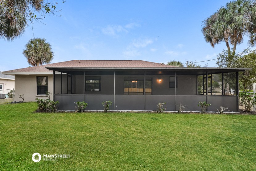 the exterior of a house with a green lawn and palm trees