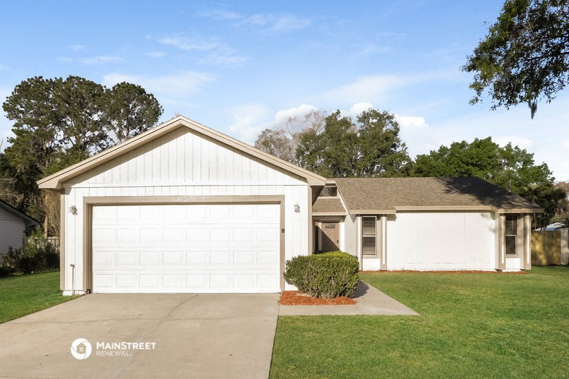 a white house with a garage and a driveway