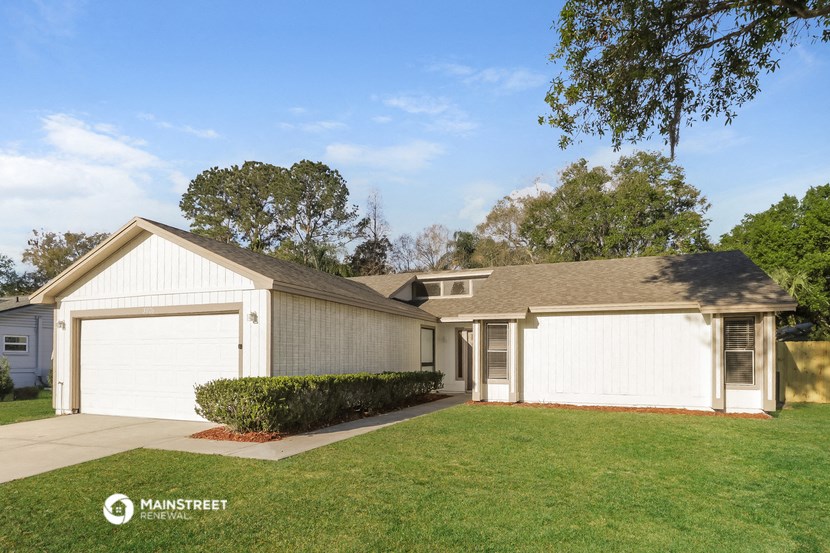 a white house with a garage and a lawn