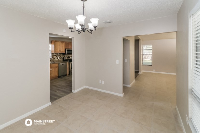 the spacious living room and dining room with the kitchen in the background