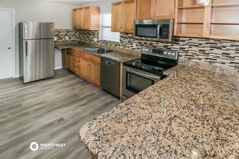 the kitchen has granite counter tops and stainless steel appliances