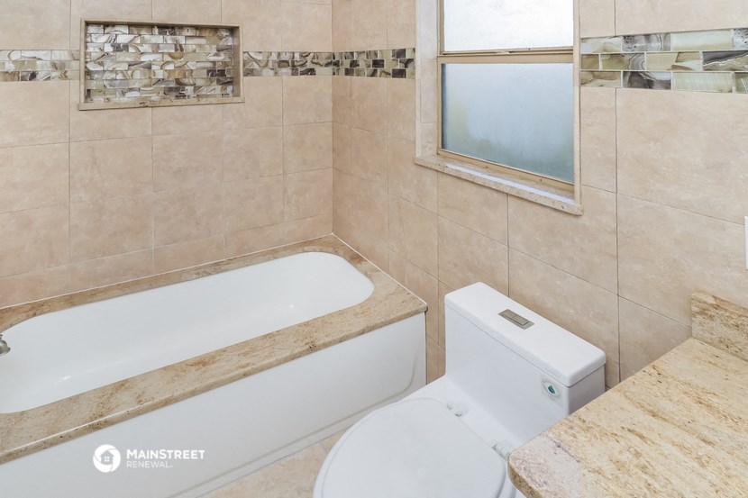 a bathroom with a tub and a toilet and a sink