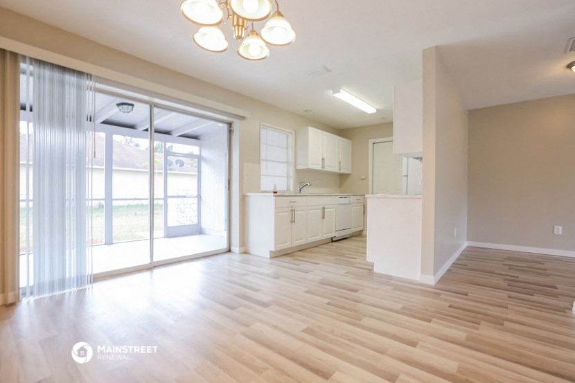an open kitchen and living room with sliding glass doors to a patio