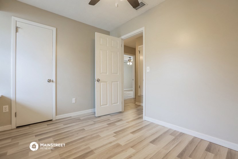 the living room and hallway of a renovated house with wood flooring