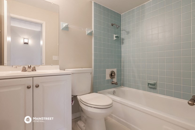 a blue and white bathroom with a toilet sink and tub
