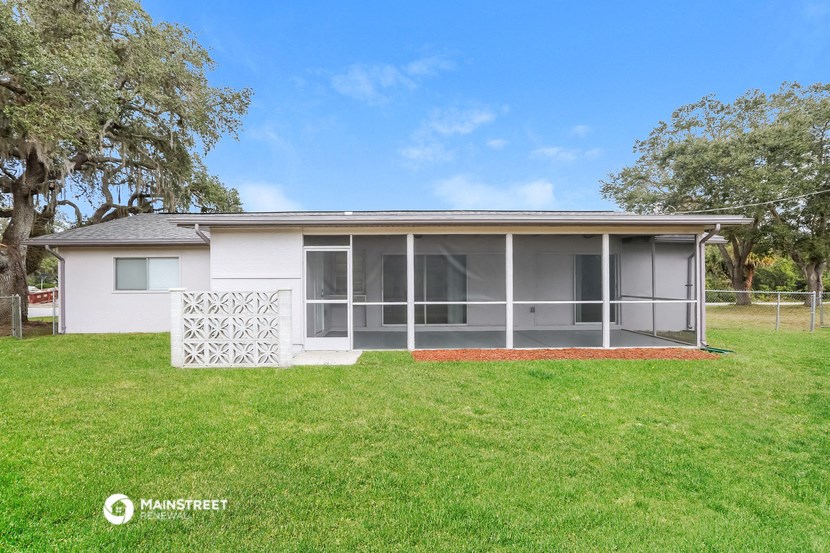 a small white house with a porch and a grass yard