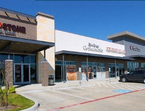 the front of a store with a parking lot