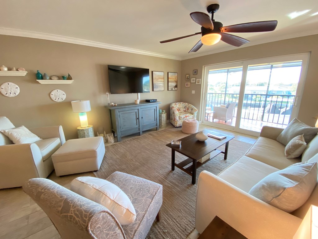 the living room has a large screen tv and couches