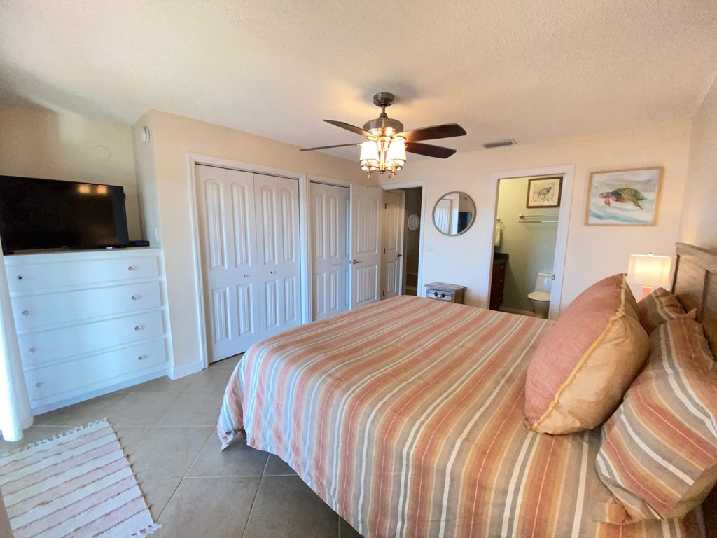 a bedroom with a large bed and a ceiling fan