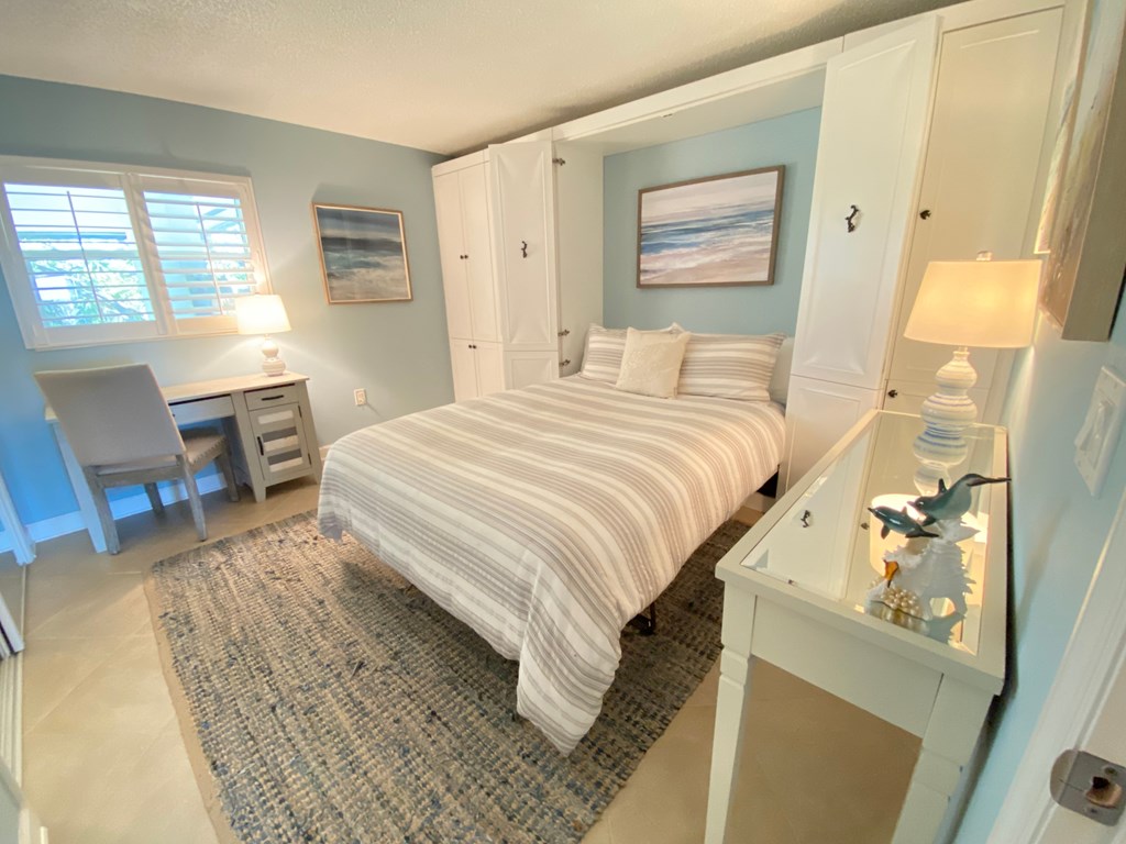 a bedroom with a bed and a desk with a chair