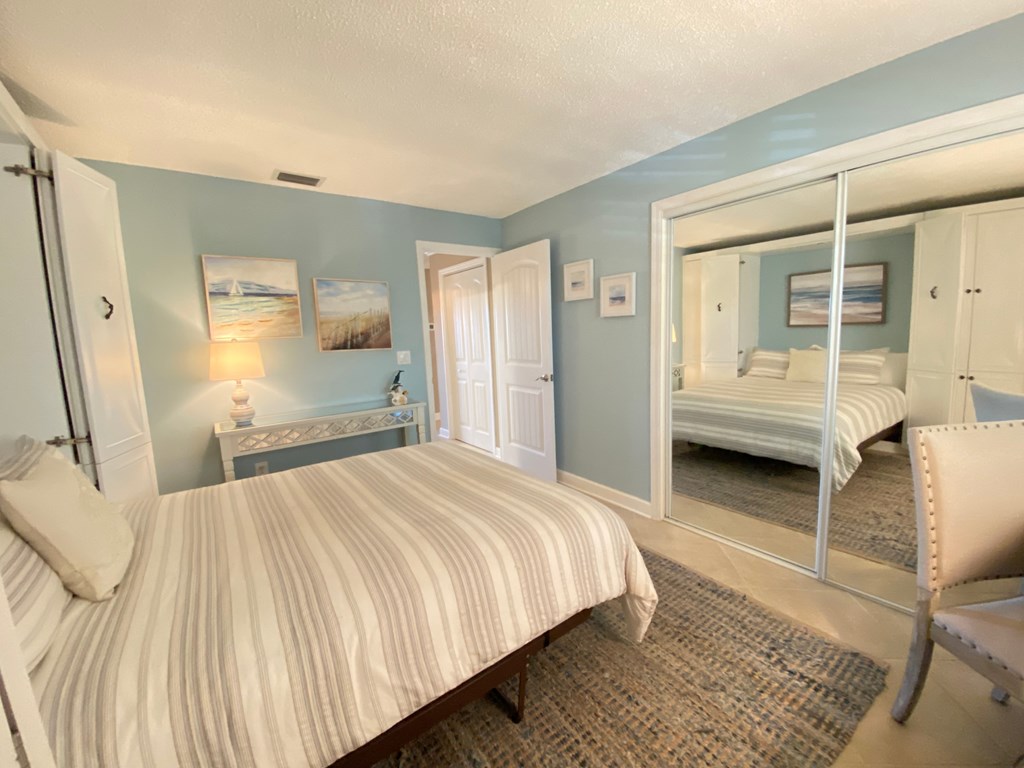 a bedroom with a large bed and a mirrored closet