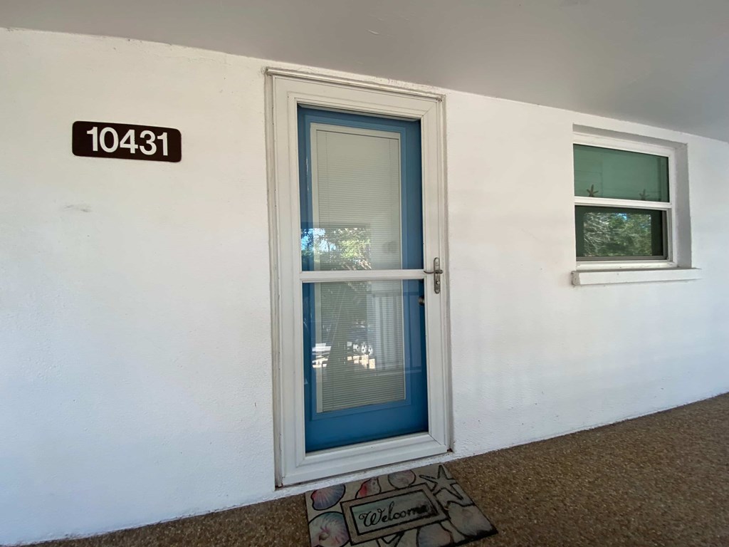 a white building with a blue door and a window