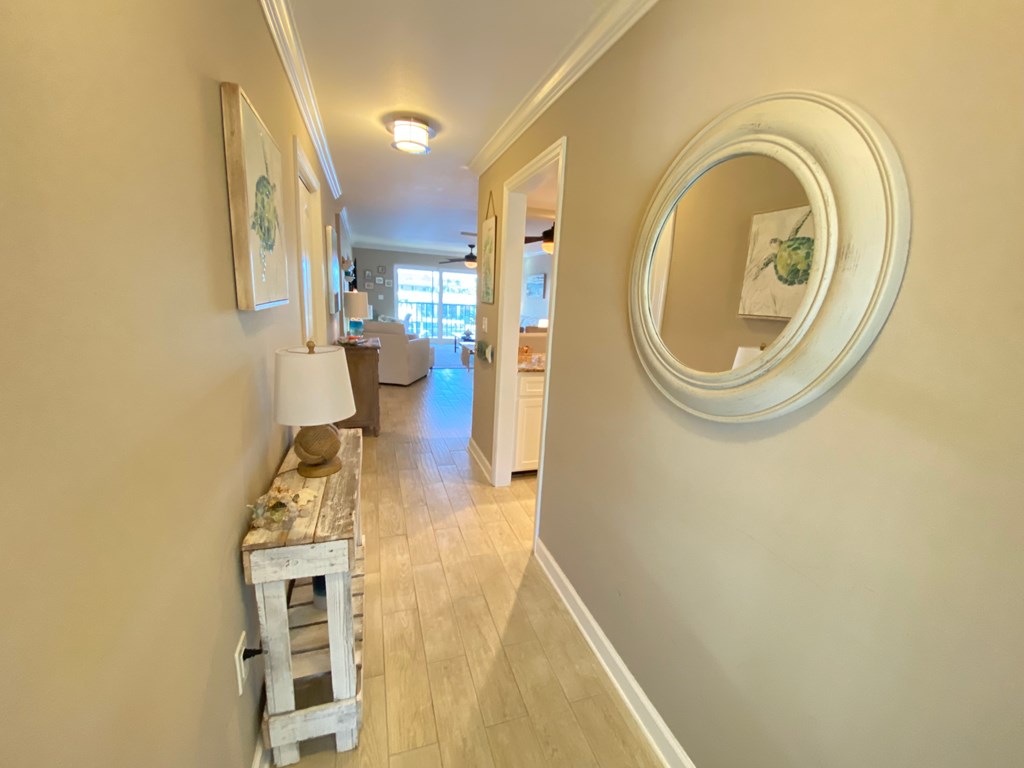 a view of a hallway with a mirror and a table