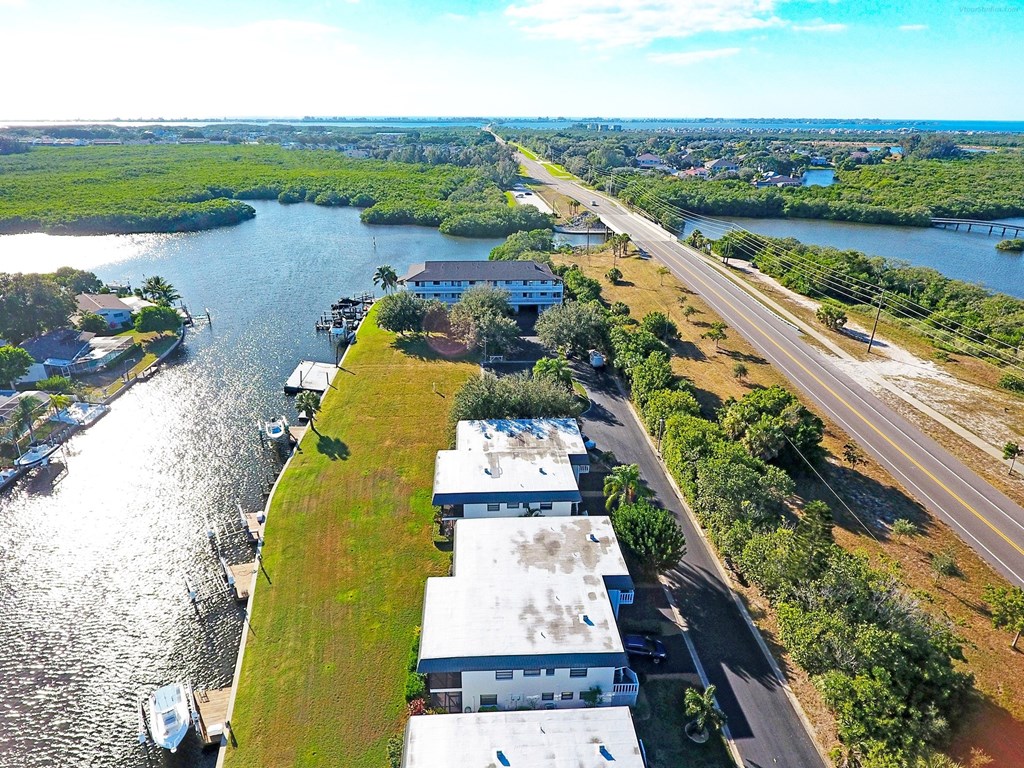 an aerial view of houses and a highway next to a river