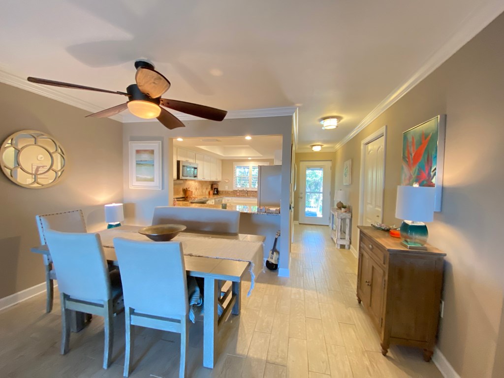 a dining room table with blue chairs and a ceiling fan