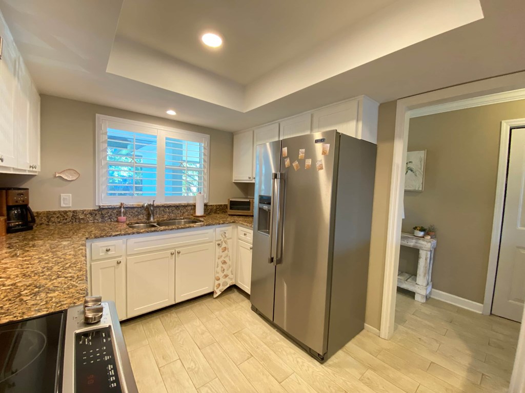 a kitchen with white cabinets and a stainless steel refrigerator