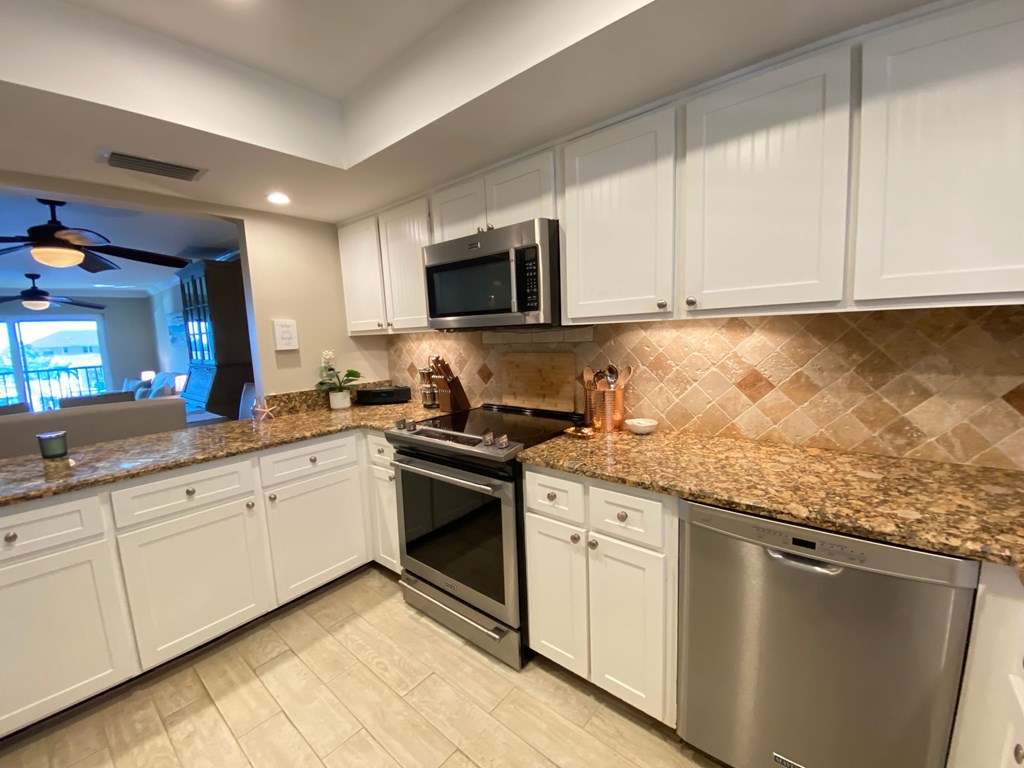 a kitchen with granite counter tops and stainless steel appliances