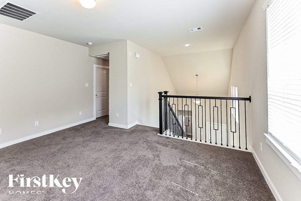 A spacious room with a staircase and a carpeted floor.