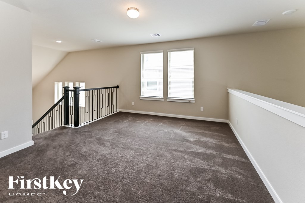 A spacious room with a staircase and a window.