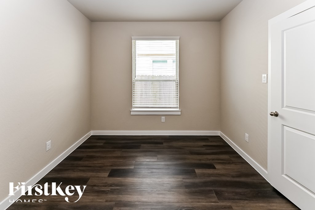 A room with wooden flooring and a white door.