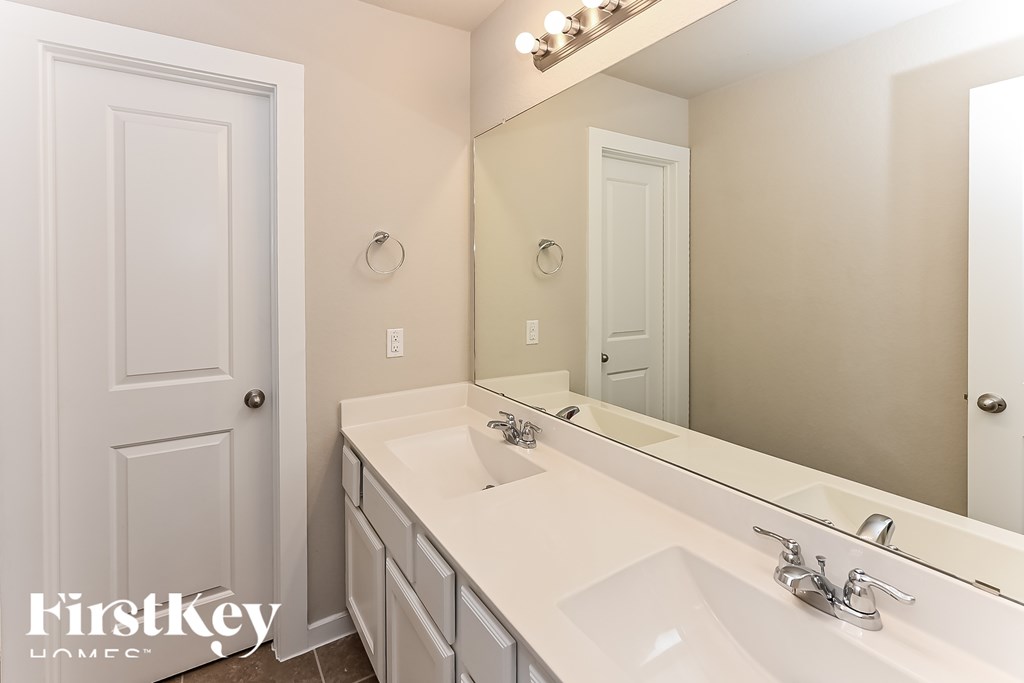 A bathroom with a white sink and a mirror.