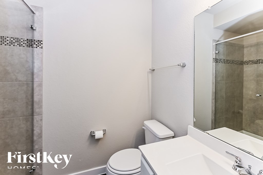 A white toilet sits next to a white sink in a small bathroom.