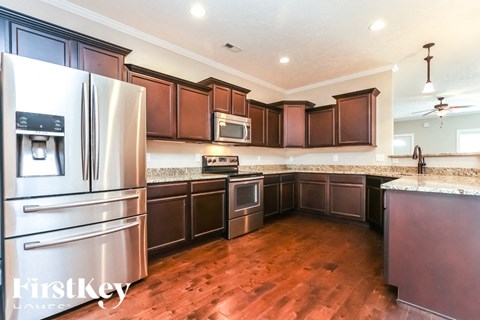 A kitchen with wooden cabinets and a stainless steel refrigerator.