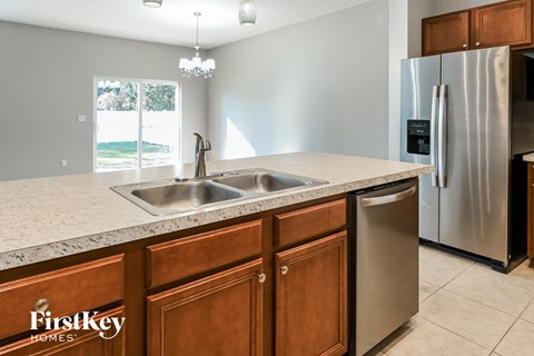 a kitchen with a sink and a stainless steel refrigerator