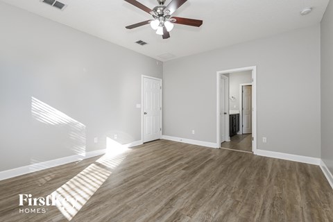 a living room with hardwood floors and a ceiling fan