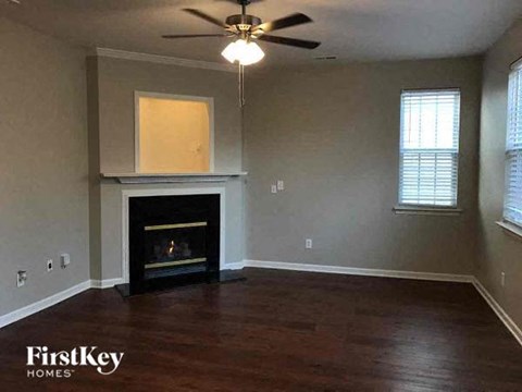 a living room with a fireplace and a ceiling fan