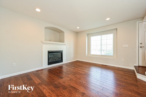 a living room with a fireplace and wooden floors