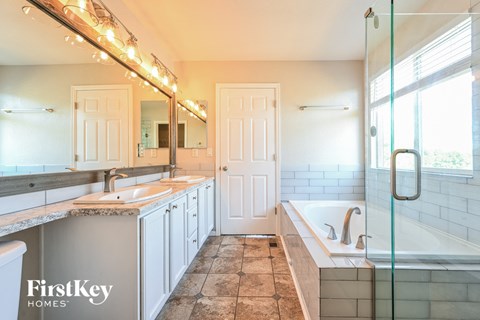 a bathroom with a tub and a sink and a mirror